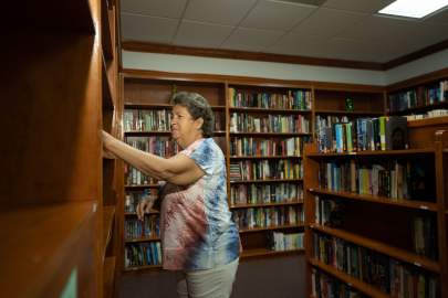 Resident taking book from bookshelf in library